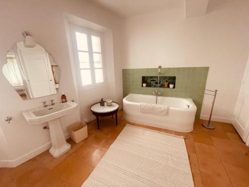 une salle de bain avec une baignoire blanche et un lavabo dans l'établissement Grande maison avec jardin Mougins vieux village, à Mougins