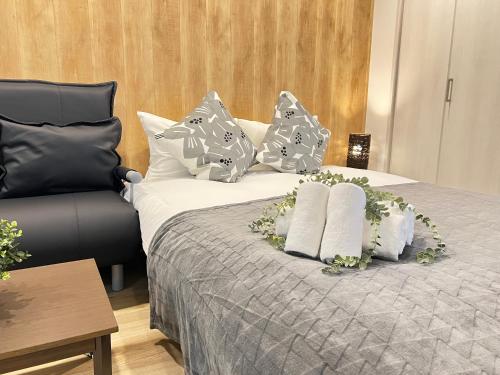 a bed with white and gray pillows on it at Ikebukuro Area 45 NishiikeApartment in Tokyo