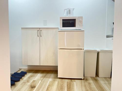 a kitchen with a refrigerator and a microwave at Ikebukuro Area 45 NishiikeApartment in Tokyo