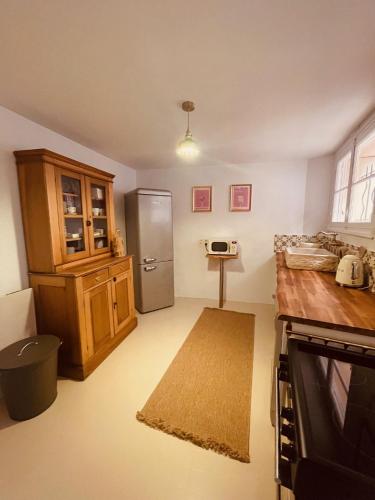 une cuisine avec un réfrigérateur en acier inoxydable et des armoires en bois dans l'établissement Grande maison avec jardin Mougins vieux village, à Mougins