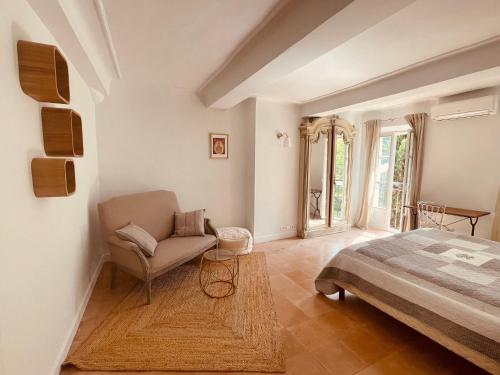 une chambre avec un lit et une chaise dans l'établissement Grande maison avec jardin Mougins vieux village, à Mougins