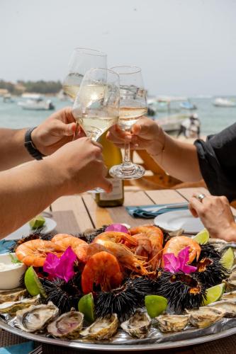 a plate of seafood and people holding glasses of wine at La Cabane du Pêcheur Atlantic Evasion in Dakar
