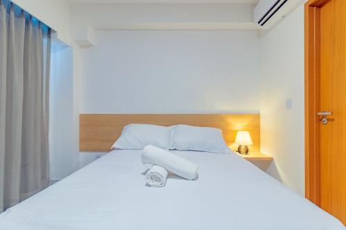 a bedroom with a white bed with two towels on it at Makia Beach #D205 - Flat em Ipojuca by Carpediem in Porto De Galinhas