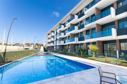 a swimming pool in front of a building at Makia Beach #D205 - Flat em Ipojuca by Carpediem in Porto De Galinhas