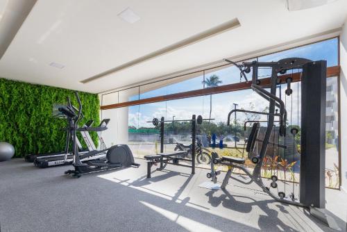a gym with cardio equipment and a large window at Makia Beach #D205 - Flat em Ipojuca by Carpediem in Porto De Galinhas
