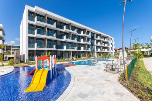 a swimming pool with a slide in front of a building at Makia Beach #D205 - Flat em Ipojuca by Carpediem in Porto De Galinhas