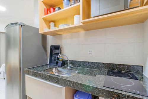a kitchen counter with a sink and a refrigerator at Makia Beach #D205 - Flat em Ipojuca by Carpediem in Porto De Galinhas