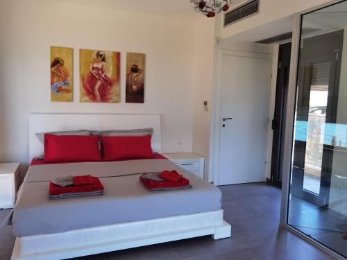 a bedroom with a bed with red pillows on it at Andromeda Sea View Villa in Epáno Eloúnda