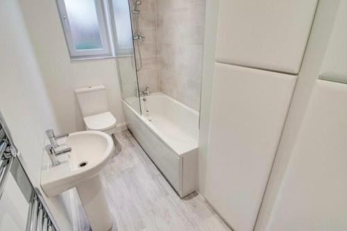 a white bathroom with a sink and a toilet at The Perfect Bedroom to Rent in Altofts