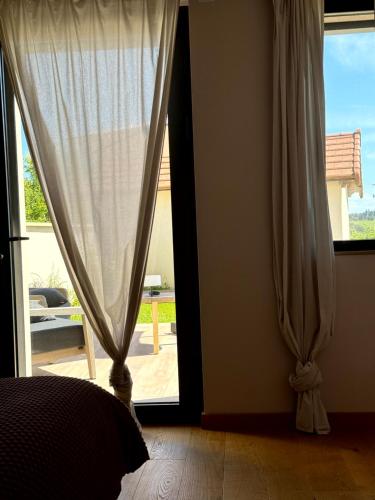 a bedroom with a bed and a window with curtains at Le Clos Vercheron in Artaix