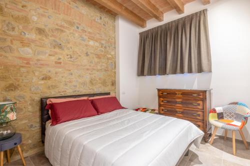 a bedroom with a bed and a brick wall at Casale Nora in Siena