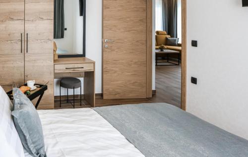 a bedroom with a bed and a desk with a mirror at Beautiful Home In Rokovci in Rokovci