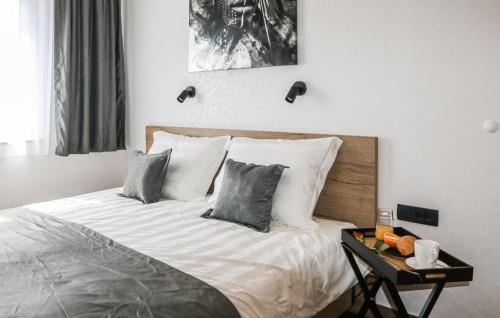 a bedroom with a bed with pillows and a table at Beautiful Home In Rokovci in Rokovci