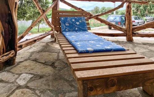 a wooden bench with a blue pillow on it at Beautiful Home In Selca With Wifi in Selca
