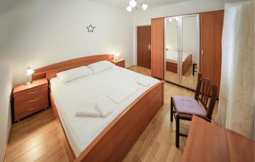 a bedroom with a bed and a chair and a mirror at Beautiful Home In Selca With Wifi in Selca