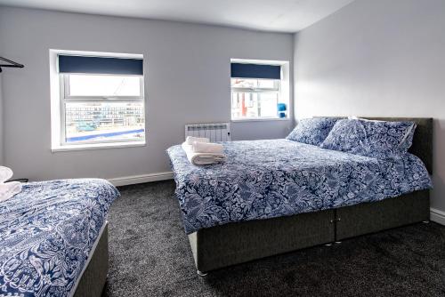 a bedroom with two beds and two windows at Maritime House Two - 4BR Sleeps 10 Near City Centre in Hull