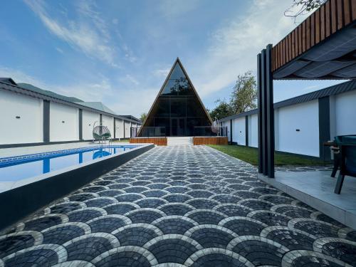 a building with a swimming pool and a pyramid at Qafqaz Wooden Chalet in Gabala