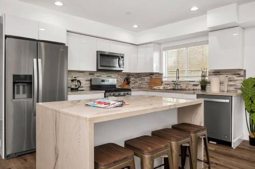 a kitchen with a large island with bar stools at Cozy 3 BR Townhouse with Balcony in Los Angeles