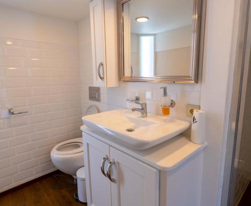 a white bathroom with a sink and a toilet at Yalikavak Matilda Mega Yacth Hotel in Bodrum City