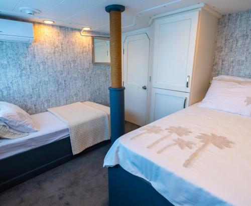 a small room with two beds and a closet at Yalikavak Matilda Mega Yacth Hotel in Bodrum City