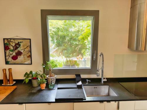 un comptoir de cuisine avec un évier et une fenêtre dans l'établissement Spacieuse Villa avec Piscine & Jardin - Hébergement Classé, à Plan-de-Cuques