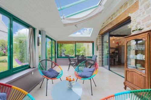 une véranda avec deux chaises et une table dans l'établissement Gite les coquelicots Proche mer, à Paimpol