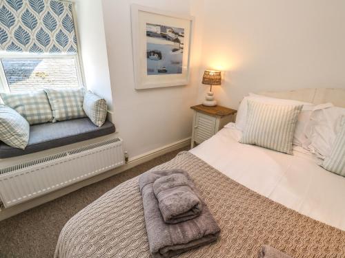 a bedroom with a bed and a window at Cormorant Cottage in St Ives