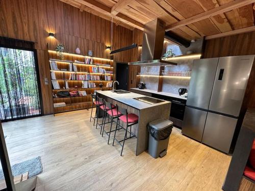 La cuisine est équipée d'un réfrigérateur et d'un comptoir avec tabourets. dans l'établissement Maison de Ville - Le Bourget, au Bourget