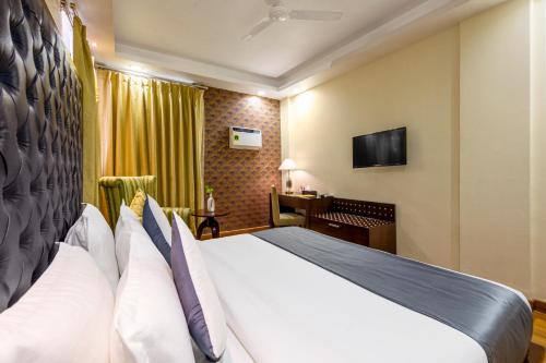 a hotel room with a bed and a desk at The Grand Orion - Kailash Colony in New Delhi