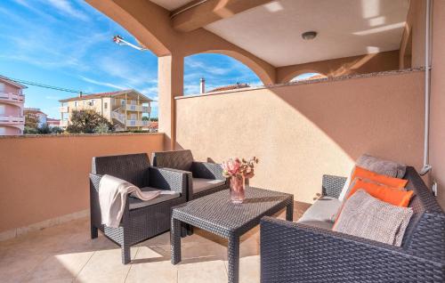 un patio con sedie e tavoli su un balcone di Amazing Apartment In Biograd Na Moru a Biograd na Moru