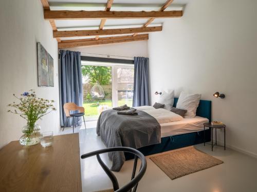 a bedroom with a bed and a table and a window at Ferienhof Schnurrum in Emmelsbüll-Horsbüll