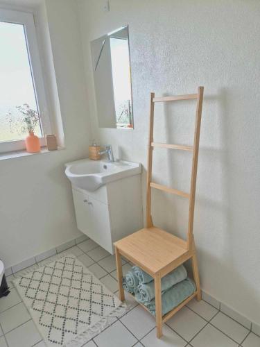a bathroom with a sink and a wooden chair at Apartment in Denmark - Hygge Villa in Otterup