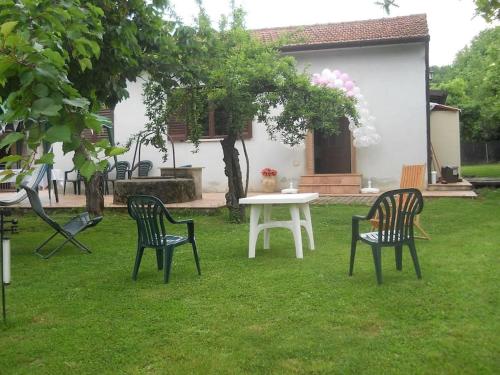 three chairs and a white table in a yard at Sezze - Casa tra mare e monti di Luigi & Fabiana in Sezze