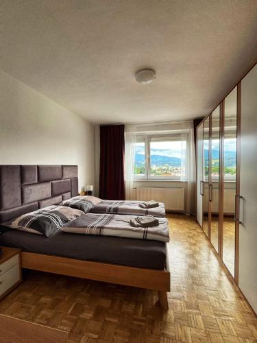 a bedroom with a large bed with a large window at Penthouse near Red Bull Ring in Knittelfeld