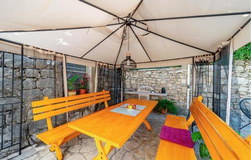 a picnic table and two benches on a patio at 2 Bedroom Gorgeous Home In Hodilje in Hodilje