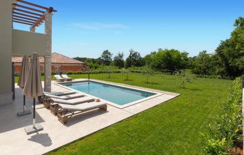 - une piscine dans une cour avec 2 chaises longues dans l'établissement 3 Bedroom Awesome Home In Nedescina, à Nedeščina