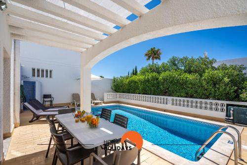 a patio with a table and chairs next to a swimming pool at #232 Vila Girasol 33 by Home Holidays in Albufeira