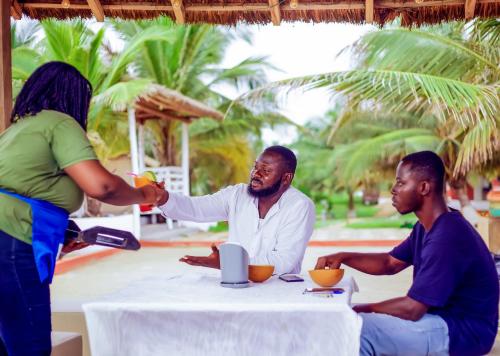 a group of people sitting around a table at Atlantic Bay Resort, Prampram in Prampram