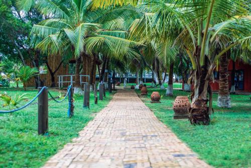 a brick path in a park with palm trees at Atlantic Bay Resort, Prampram in Prampram