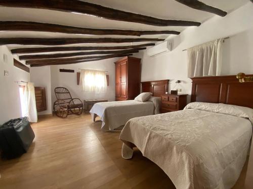 ein Schlafzimmer mit zwei Betten und einer Holzdecke in der Unterkunft Alojamiento en Magina la casilla de Eustaquia in Bedmar