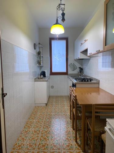 eine kleine Küche mit Tisch und Fenster in der Unterkunft Castione della Presolana in Castione della Presolana