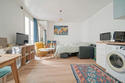 - un salon avec un lit et un lave-linge dans l'établissement Doorman Best Studio in 12th, à Paris