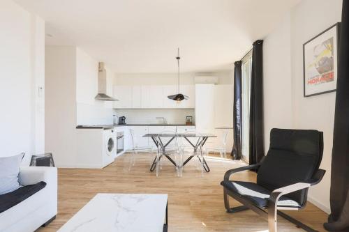 un salon avec une table et des chaises et une cuisine dans l'établissement 3 pièces à 5 min de la frontière de Monaco, à Beausoleil