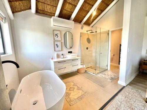a bathroom with a white sink and a shower at Laid back luxury canal house in St Francis Bay