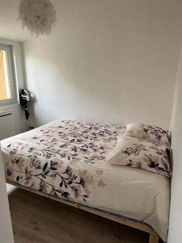 une chambre avec un lit avec un couvre-lit fleuri dans l'établissement madeline house's, à Mindin