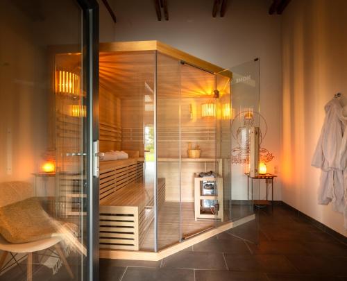 a glass shower stall in a room with a chair at Ferienhof Schnurrum in Emmelsbüll-Horsbüll