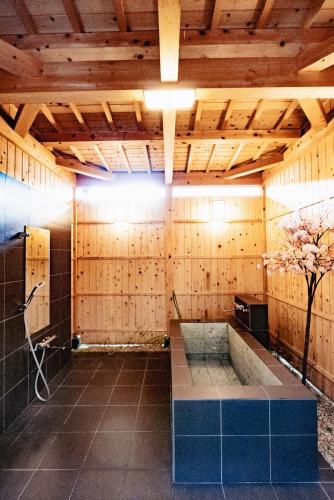 a large bathroom with a tub and a tree in it at ～Fushimi Inari～露天風呂付の一棟貸切のゲストハウス in Kyoto