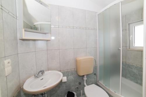 a bathroom with a sink and a toilet and a shower at Villa Nada - room for 2 in Duće