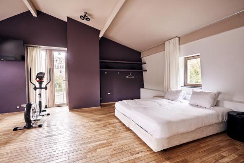 a bedroom with a large white bed and a desk at Le Reflet de l'Ourthe in Durbuy
