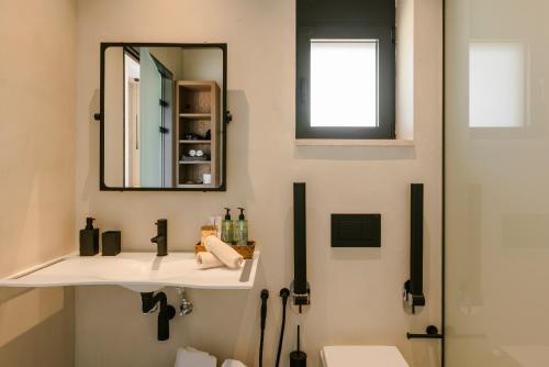 a bathroom with a sink and a mirror at Mast Luxury Residences in Gargaliánoi